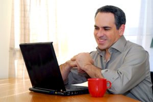 man sitting at a desk and looking into his computer